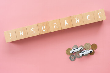 自動車保険｜「INSURANCE」と書かれた積み木、家と人のおもちゃ、お金