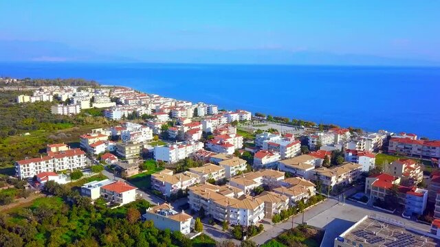 Aerial view of Greek coastal city by Ionian Sea, blue Gulf of Corinth and houses