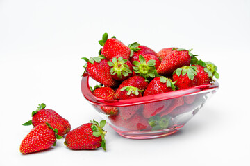 Ripe, fresh strawberries in a glass vase on a light background. Vegetarian food concept. Food photo.