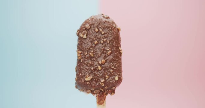 Close up detail Time-Lapse - melted chocolate ice cream bar isolated on blue pink background.