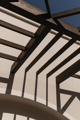 Obraz premium Modern east style building with beige walls and rail sunlight shadows on walls. Aesthetic abstract minimal architecture facade design concept background