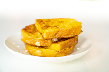 croutons of bread and egg in a plate on a white table.