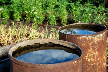 old iron barrels for storing water in the garden
