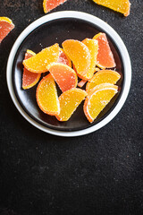 slices of marmalade jelly candy sweets candy citrus orange, tangerine, grapefruit, lemon on the table, healthy food meal snack copy space food background rustic. top view