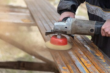 A worker grinds metal at a construction site.