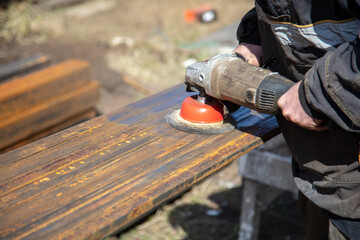 A worker grinds metal at a construction site.