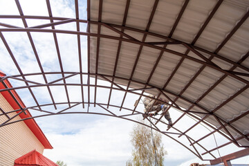 Workers are installing a metal canopy.