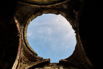 Old turkish bath ruins in iznik. It is established by ottoman empire period made of red bricks wall and currently it is abandoned and brownfield with demolished ist dome and sky is observed.