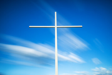 Christian cross against clouds