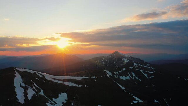 Sunset in mountains. Beautiful sun above peak. Aerial cinematic landscape. Flyover National Park. Sunrise Clouds 