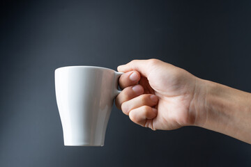 hand holding cup on black