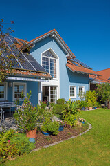 family home with photovoltaic panels, backyard garden