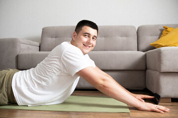 Fitness, exercise, lifestyle and healthy. Sports man do workout at home on mat in interior of living room, profile, free space