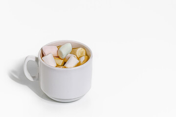 cup of coffee with sweet marshmallows on white table