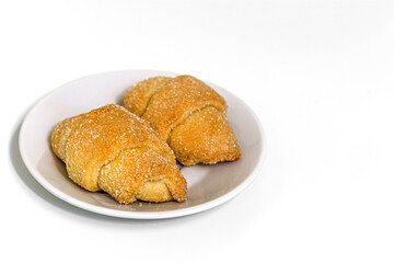 sweet homemade shortcrust pastry bagels on a porcelain plate on a white surface