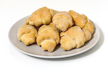 sweet homemade shortcrust pastry bagels on a porcelain plate on a white surface