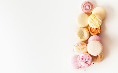 Flat lay of yellow and pink macaroons on the white background with a free space for text.