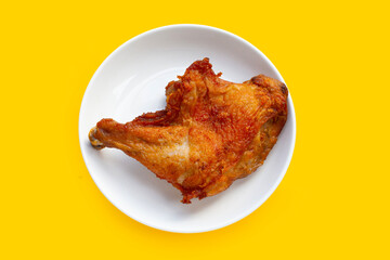 Fried chicken in white plate on yellow background.