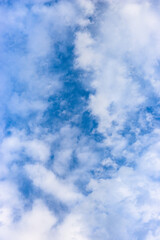 Obraz premium Sunny blue sky with fully covered white clouds vertical view