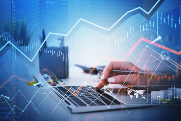Businesswoman hands or stock trader analyzing stock graph chart by using laptop to buy or sell stock, internet trading concept. Digital interface. Pen om hand for notes
