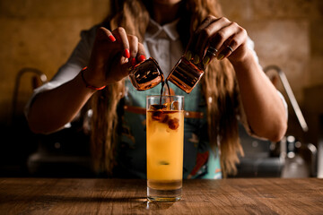 The process of creating bumble coffee. Pouring espresso into glass with orange juice