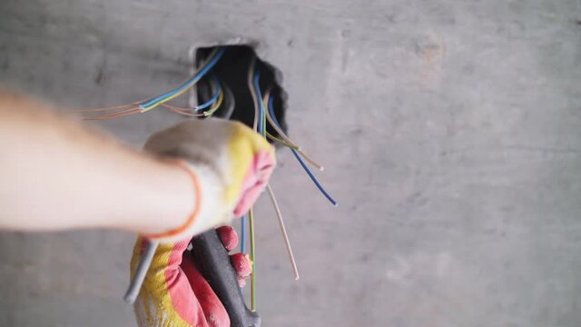 electrician strips wires in the apartment