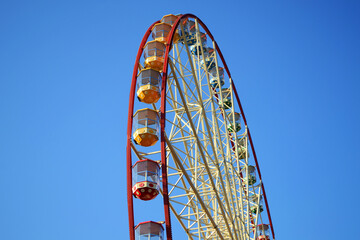 Round Ferris wheel on a background of blue sky.
