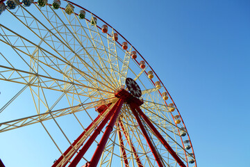 Round Ferris wheel on a background of blue sky.