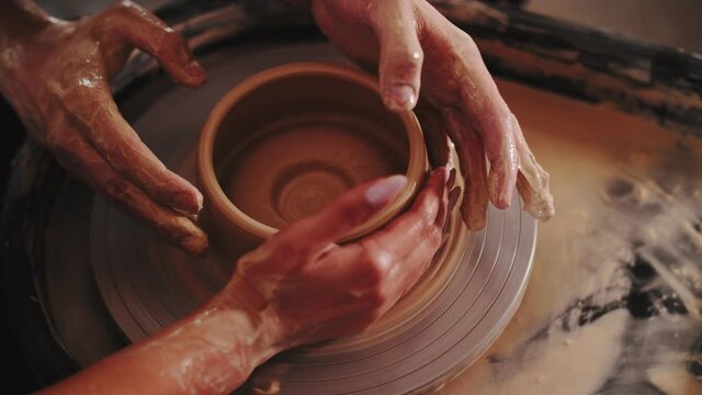 working with a potter's wheel in pairs close-up 