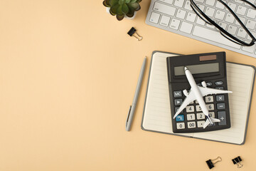 Top view photo of plant glasses on keyboard plane model on calculator grey planner pen and binders...