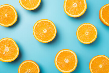 Top view photo of juicy orange slices on isolated light blue background