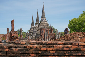 Fototapeta na wymiar view to Wat Phra Si Sanphet temple in Ayutthaya historical park and temple bricks wall ruins remains, Ayutthaya, Thailand that the destination attractive tourists both Thai and foreigners