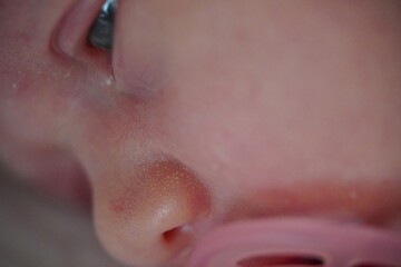 Fototapeta premium Newborn baby face. Open eyes. With pink Pacifier. close up view macro closeup. High quality photo
