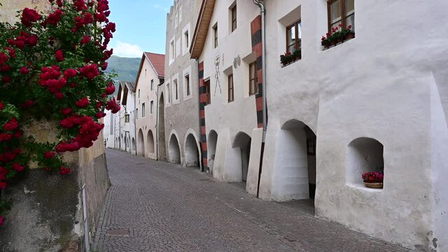 Glorenza, Trentino, Italy, June 2021. The Via dei Portici the characteristic whitewashed arcades at the base of the facades of the houses of the pretty medieval village.