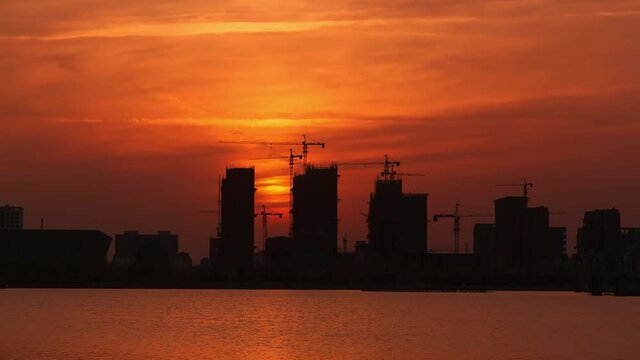 Time-lapse of building construction by the river at dusk