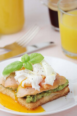 Breakfast with a sandwich with poached egg and avocado