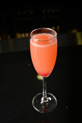 bartender special cold pink fruit punch cocktail wine or mocktail with cherry pop juice in tall glass goblet on black background luxury hotel pub iced beverage menu