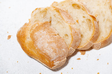 white bread cut into slices on white background, closeup