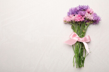 Bouquet of beautiful cornflowers on light table, top view. Space for text