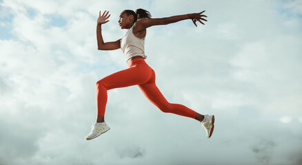 Athletic woman running and jumping outdoors