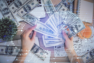 Multi exposure of technology drawing hologram and us dollars bills and man hands. Data concept