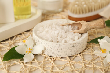 Sea salt in bowl and beautiful jasmine flowers on white table