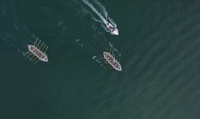 Aerial drone view of sport canoe operated by team in mediterranean clear waters.
