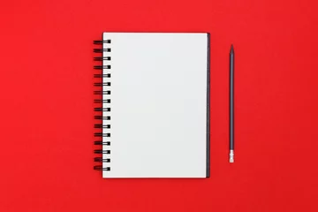 Foto op Plexiglas Blank spiral notebook and pencil on red background. Top view with copy space for input the text. © Sergey