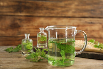 Stinging nettle extract on wooden background. Natural hair care