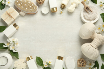 Jasmine flowers and set of spa essentials on white wooden table, flat lay. Space for text