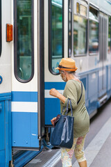 Ältere Dame die in ein Tram steigt