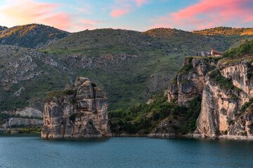 Pulpito de Canales, an impressive rock in the Canales reservoir, Granada, with the Sierra Nevada in the background.