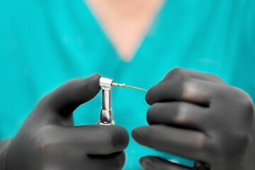 Close up of dentist hand with special tool for removing nerve from tooth. Dentist orthopedist tools.