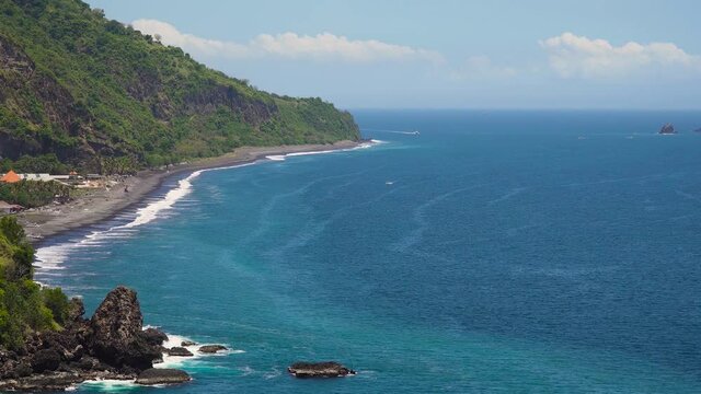 Bali, sea surf with breaking waves on the coast, Indonesia. Ocean with waves and rocky cliff.